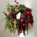 Decorative Christmas wreath with greenery, red berries, gold ornaments, and a red ribbon on a neutral background.