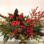 Decorative floral arrangement with red flowers and greenery on a white background