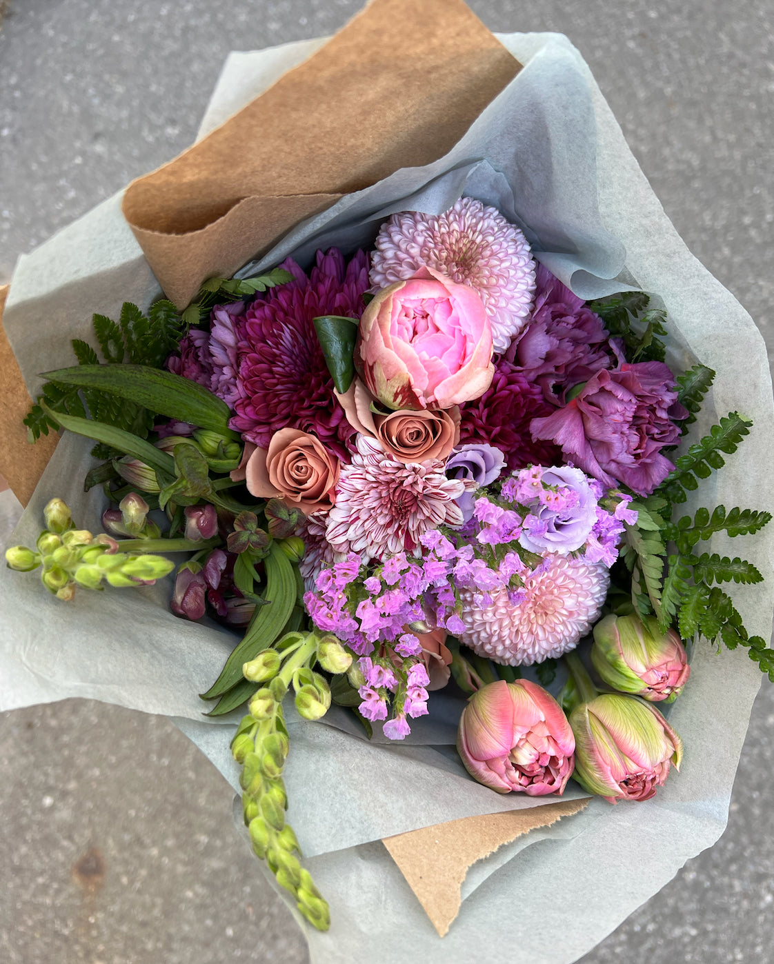 local flower fresh bouquet, bright colours wrapped in tissue and brown paper for a gift